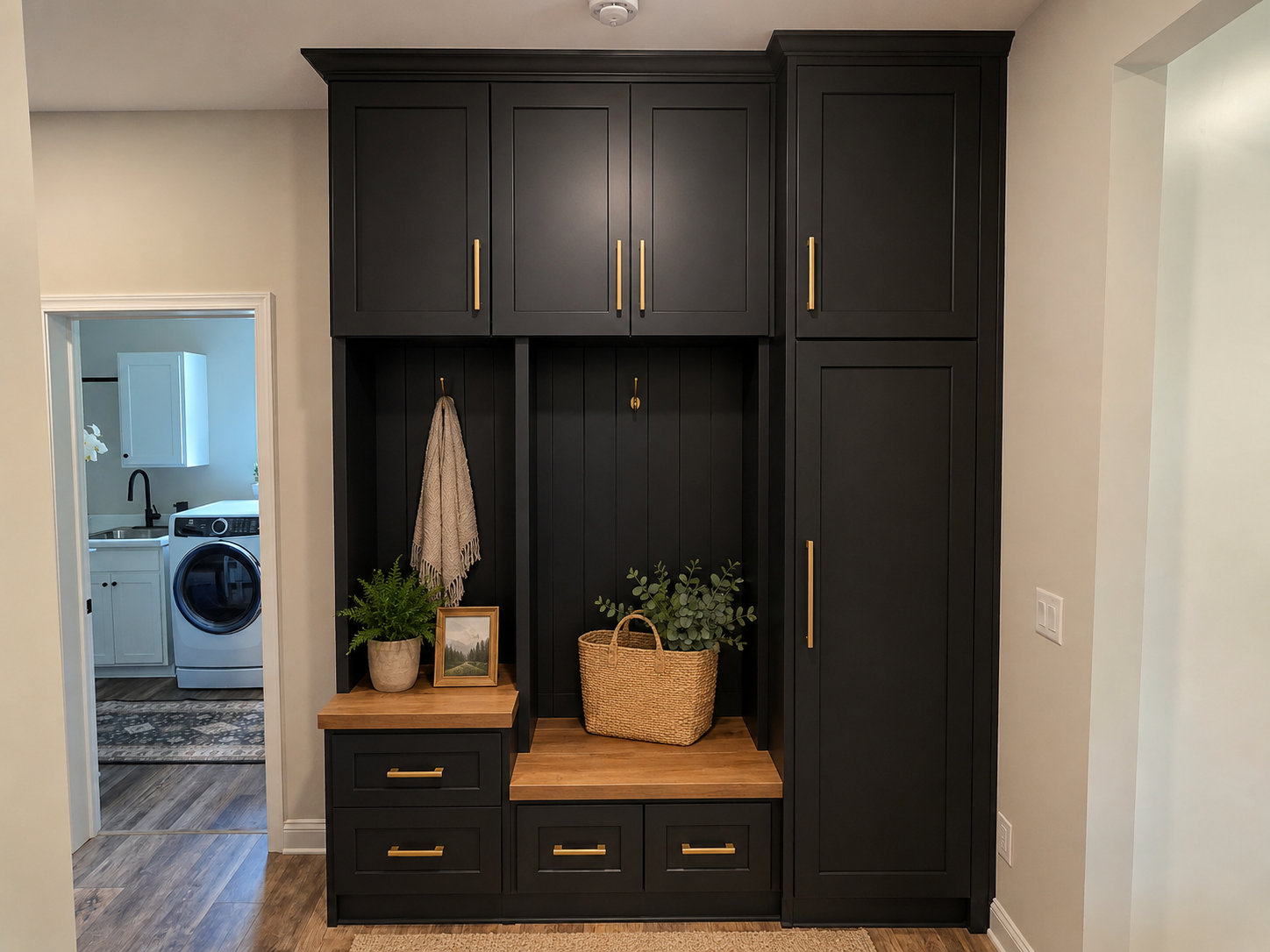 Finished black mudroom cabinetry with brass hardware